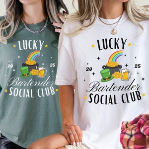 May include: Two green and white t-shirts with the text "Lucky Bartender Social Club" and a rainbow, pot of gold, and beer mug graphic. The text "20" and "25" are on either side of the graphic.