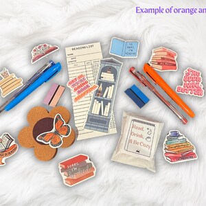 Op de afbeelding: Een verzameling boek-thema stickers met zinnen zoals "Get in, we're going book shopping", "The book was better", en "Read, Drink, & Be Cozy". De stickers zijn op een witte achtergrond met een kurken onderzetter, pennen en een leeslijst.