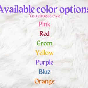 Op de afbeelding: Een witte, pluche achtergrond met de tekst "Available color options" en "You choose two" in paars. De volgende kleuren worden in tekst vermeld: roze, rood, groen, geel, paars, blauw en oranje.