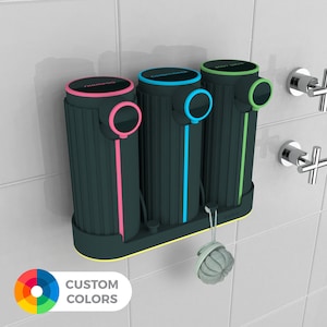May include: A wall-mounted shower dispenser set with three dark teal containers labeled "Shampoo", "Conditioner", and "Body Wash". Each has a colored accent: pink, blue, and green. A loofah hangs from the base. The text "CUSTOM COLORS" is visible.
