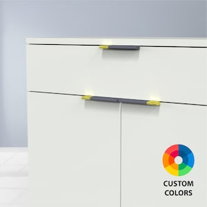 Puede incluir: Armario blanco con dos cajones y una puerta, con tiradores en gris oscuro y dorado. La imagen incluye una rueda de color con el texto "CUSTOM COLORS".