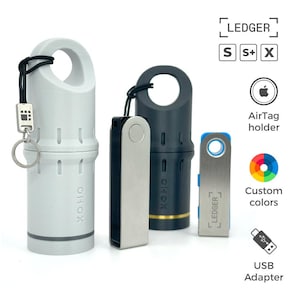 Puede incluir: Una colección de carteras de hardware Ledger y accesorios. La imagen muestra una cartera Ledger blanca, negra y plateada, junto con una cartera Ledger azul y plateada. Los accesorios incluyen un adaptador USB y un soporte para AirTag. El texto de la imagen dice "LEDGER" y "Colores personalizados."