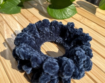 May include: A dark blue fuzzy hair scrunchie.