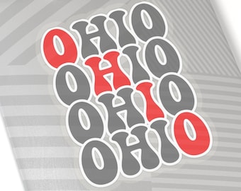 May include: A sticker with the word "OHIO" repeated four times in a stacked design. The letters are gray with red outlines. The sticker is on a gray and white striped background.
