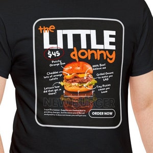 May include: Black t-shirt with a graphic of a burger labeled "the little donny" with a price of $4.5 and the text "NEW BURGER" and "ORDER NOW".