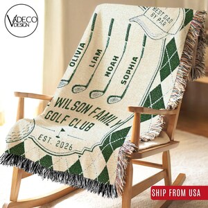 May include: A woven throw blanket featuring a cream background with dark green argyle patterns, four golf club illustrations, and the text "WILSON FAMILY GOLF CLUB", "EST. 2026", and "BEST DAD BY PAR" with names Olivia, Liam, Noah, and Sophia.