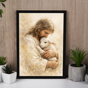 May include: A framed print depicts a tender scene of a figure with long hair and a beard embracing a lamb. The artwork is rendered in soft, warm tones, with the figures in white robes and the background in muted earth tones.