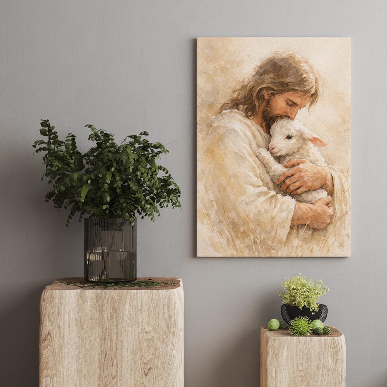 May include: A framed print depicts a person with long hair and a beard tenderly holding a lamb. The artwork is rendered in soft, warm tones, creating a serene and comforting atmosphere. The print is displayed on a neutral-colored wall.
