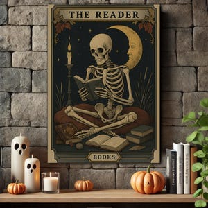 May include: A framed print featuring a skeleton reading a book, with the text "THE READER" at the top and "BOOKS" at the bottom. The background is dark with a crescent moon and stars. The print is displayed on a wooden shelf with candles and pumpkins.