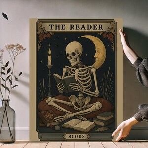 May include: A vintage-style poster featuring a skeleton reading a book, with the text "THE READER" at the top. The artwork includes a crescent moon with a face, a lit candle, and the word "BOOKS" at the bottom. The color palette is primarily beige, black, and gold.