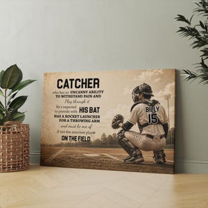 May include: A baseball-themed canvas print featuring a catcher in a crouched position on a baseball field. The print includes text describing the catcher's role and the name "BILLY" with the number "15". The color palette is neutral with brown and beige tones.