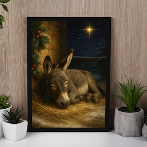 May include: Framed art print of a sleeping donkey in a stable, illuminated by a star. The artwork features a brown donkey resting on hay, with a stone wall and holly branches in the background. The night sky is visible.