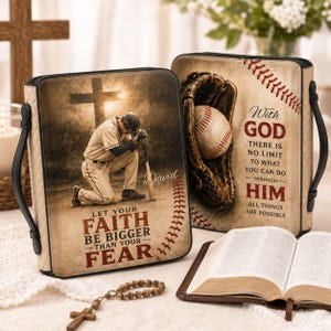 May include: Two rectangular beige Bible covers with black trim and handles. One cover features a baseball player kneeling before a cross with the text 'LET YOUR FAITH BE BIGGER THAN YOUR FEAR'. The other shows a baseball in a glove with the text 'WITH GOD THERE IS NO LIMIT TO WHAT YOU CAN DO THROUGH HIM ALL THINGS ARE POSSIBLE'.