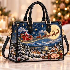 May include: A structured handbag with black handles and trim, featuring a printed winter scene of Santa in a sleigh pulled by reindeer flying over a snowy village. A wooden sign in the foreground displays the name Sophia in red script.