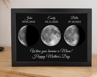 May include: A black framed print with three black and white moon images. The dates "09.05.2018", "03.11.2020", and "07.18.2022" are printed above each moon image. The text "When you became a Mom! Happy Mother's Day" is printed below the moon images.