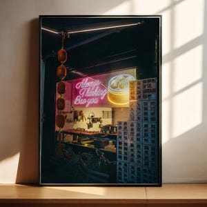 Könnte beinhalten: Gerahmter Druck eines Neonschilds mit der Aufschrift "Always Thinking Bao You" über einer Restaurantszene. Das Bild zeigt rote Laternen, Essensauslagen und Kisten mit Lebensmittelaufklebern. Das Thema ist asiatische Küche.