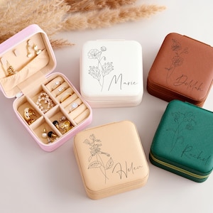 May include: Four small square jewelry boxes with floral designs and personalized names. The boxes are in pink, brown, green, and beige.