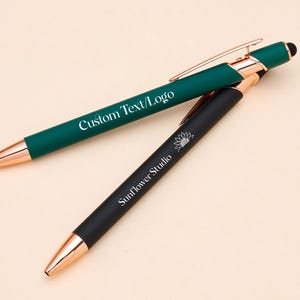 May include: Two pens with rose gold accents. One pen is green with the text "Custom Text/Logo" and the other is black with the text "Sunflower Studio".