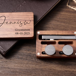 May include: Wooden box containing a tie clip and cufflinks. The box is engraved with the name "Dennis" and the text "Groomsmen 08-05-2025".