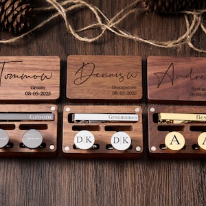 May include: Three wooden boxes with engraved names, dates, and titles such as "Groom", "Groomsmen", and "Best Man". Each box contains a tie clip and cufflinks.
