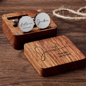 May include: A wooden box with a hinged lid, engraved with the name "Jonathan" and the words "Best Man" with the date "08-05-2025". The box contains two silver cufflinks, one engraved with "Best Man" and the date "08-05-2025", and the other engraved with "Jonathan".