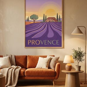 May include: A framed wall art print featuring a stylized landscape of a lavender field in Provence. The illustration depicts rows of purple lavender, a stone house, cypress trees, and a setting sun in a gradient sky. The word PROVENCE is printed.