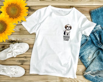 May include: White t-shirt with a cartoon Shih Tzu dog graphic and the text "Shih Tzu" printed on the front. The shirt is laid out on a wooden surface with sunflowers, white sneakers, and blue jeans.