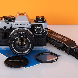 Olympus OM10 film camera and 50mm lens, strap and user manual