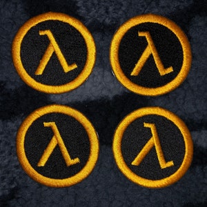 May include: Four black and gold embroidered patches with the Lambda symbol from the Half-Life video game series.