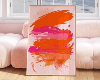 Puede incluir: Impresión de arte abstracto con pinceladas de color naranja, rosa y dorado sobre un fondo rosa claro. La impresión está enmarcada en un marco dorado y está colgada en una pared sobre un sofá blanco.