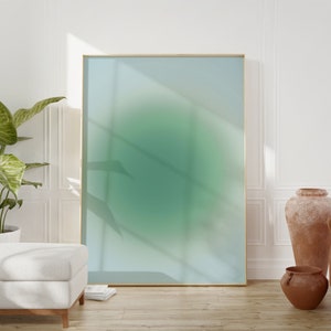 May include: A framed abstract art print with a green and blue gradient. The print is hanging on a white wall with a wooden floor.