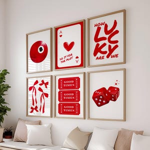May include: A set of six framed prints with a red and white color scheme. The prints feature a red billiard ball, a playing card with a red heart, a red dice, a red bow, and the words "How Lucky Are We" and "Good Times".