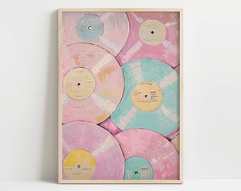 May include: A framed artwork featuring a collection of pastel-colored vinyl records. The records are in shades of pink, blue, and yellow, with visible labels. The artwork is in a light wooden frame, creating a vintage aesthetic.