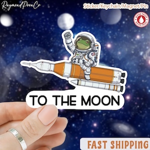 May include: A white ceramic mug with a black handle and the text "But First, Coffee" in a black, handwritten-style font. The mug is on a white surface.