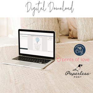 May include: A laptop computer displaying a digital invitation with a blue hot air balloon and the text "Welcome little one". The invitation is on a white background with a light blue border. The laptop is on a beige blanket with a white pillow behind it.