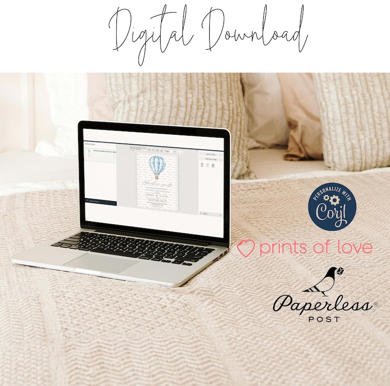 May include: A laptop computer displaying a digital invitation with a blue hot air balloon and the text "Welcome little one". The invitation is on a white background with a light blue border. The laptop is on a beige blanket with a white pillow behind it.