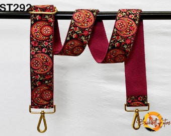 May include: A red and black patterned fabric strap with gold metal clasps. The strap is shown hanging on a black rod. The text "ST292" is visible in the top left corner of the image.