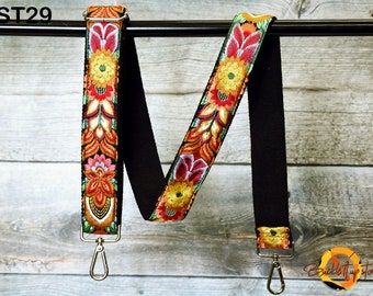 May include: Black canvas bag strap with a colourful floral embroidered design. The strap has two silver swivel clips. The strap is labelled "ST29".