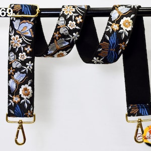 May include: Black and white floral patterned adjustable strap with gold hardware and a gold swivel clasp. The strap is shown hanging from a black rod. The text "ST269" is visible in the top left corner of the image.