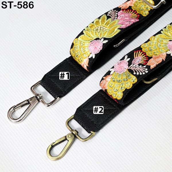 May include: Two black adjustable straps with gold metal clasps. The straps are decorated with embroidered floral patterns in pink, yellow, and green. The straps are labelled #1 and #2.