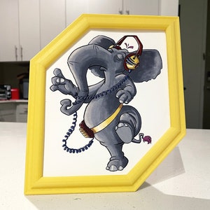 Puede incluir: Un elefante gris con un cinturón a rayas amarillo y negro, que lleva auriculares rojos y dorados, está ilustrado en un marco hexagonal amarillo.