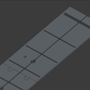 以下が含まれることがあります： グレーの四角い金属板で、グリッドパターンと複数の穴が開いています。この板は、木工やその他のクラフトに使用するために設計されています。
