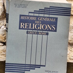 Può includere: Un libro vintage intitolato "Histoire Générale des Religions Grecia - Roma" di Aristide Quillet Éditeur. La copertina del libro è di colore grigio-azzurro chiaro con un design geometrico in bianco e nero.