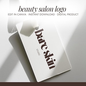 Peut inclure: Une carte de visite blanche avec les mots "bare skin studio" en marron foncé. La carte est inclinée, projetant une ombre sur la surface blanche. Le texte "beauty salon logo" est en haut.