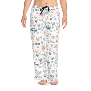 May include: White pyjama trousers with a colourful heart pattern. The hearts have different words on them, including "Mom", "Mommy", "Mama", "Mami", and "Momma".