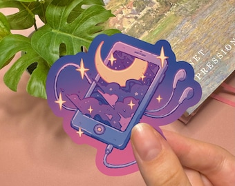 May include: A die-cut sticker featuring a purple smartphone with a screen displaying a crescent moon, clouds, and stars. The phone is connected to wired earbuds with a cord, and the design is accented with small, four-pointed yellow stars.