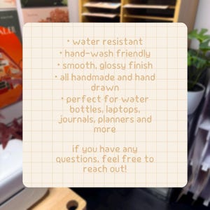 May include: A square, cream-colored informational card with a grid pattern featuring brown text: water resistant, hand-wash friendly, smooth, glossy finish, all handmade and hand drawn, for water bottles, laptops, journals, planners and more.