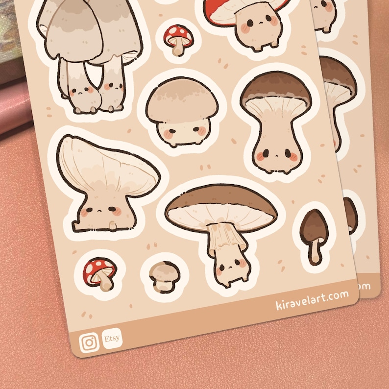 May include: A sticker sheet featuring various cartoon mushrooms with faces in shades of brown, beige, and red. The sheet includes the text kiravelart.com, an Instagram icon, and an Etsy icon. The background of the sticker sheet is light beige.