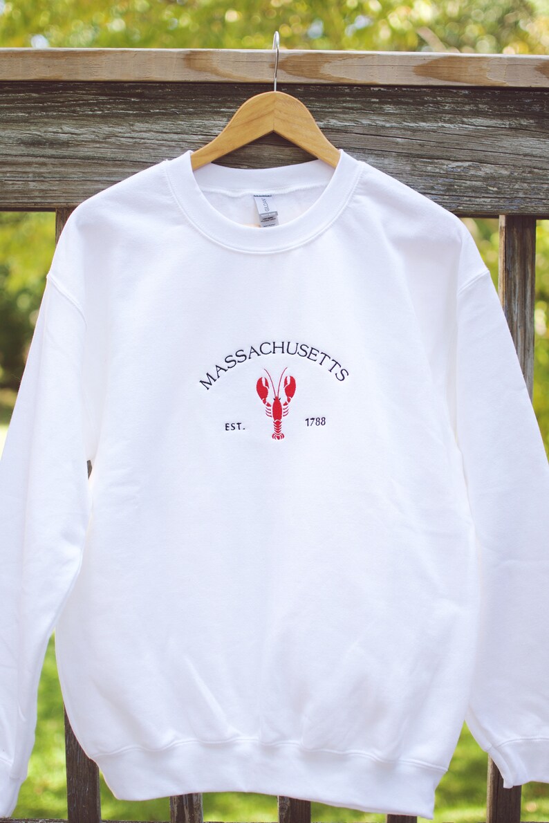 May include: White sweatshirt with a red lobster graphic and the text "MASSACHUSETTS EST. 1788"