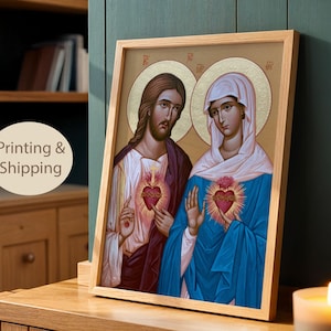 May include: A framed religious icon print featuring the Sacred Heart of Jesus and the Immaculate Heart of Mary. Both figures have golden halos, with Jesus in a white and purple robe and Mary in a white head covering and blue mantle.